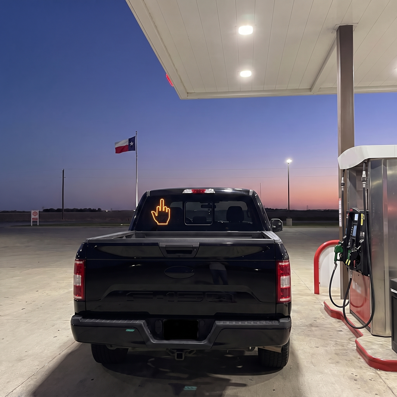The Flicker glowing in a pickup's rear window at a Texas gas station
